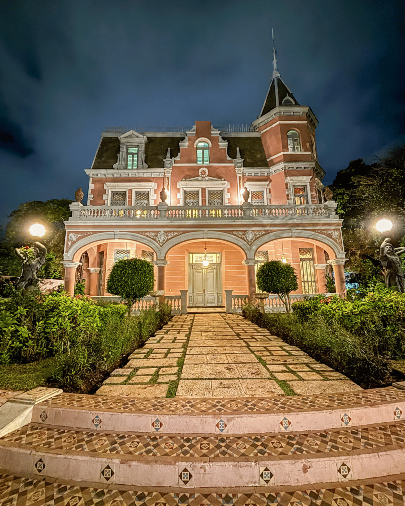 "Entrada iluminada de la casa principal durante el tour nocturno El Pinar, mostrando el ambiente misterioso y encantador del recorrido."